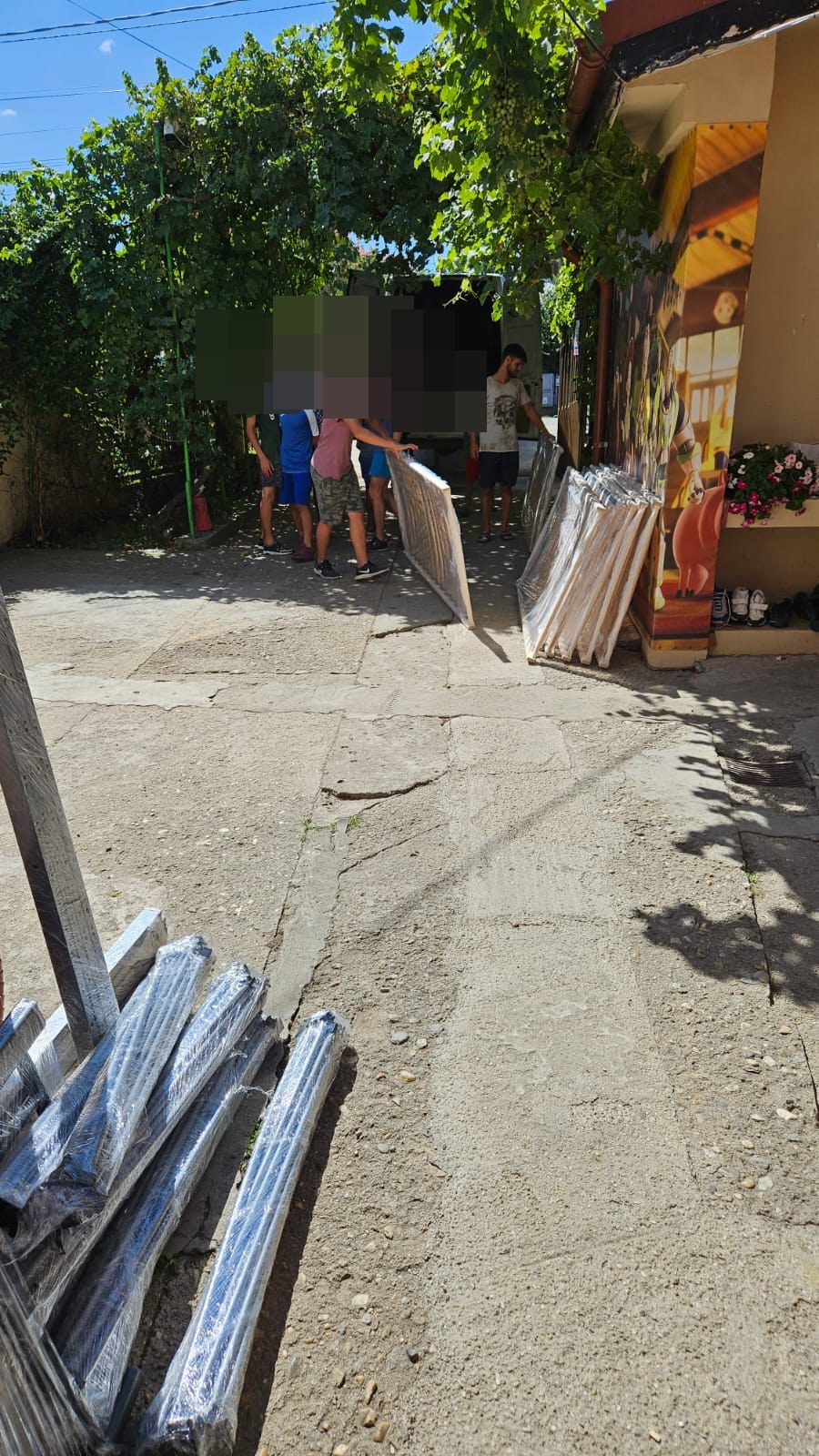 Copiii ajutând la descărcarea unor materiale, cu fețele protejate